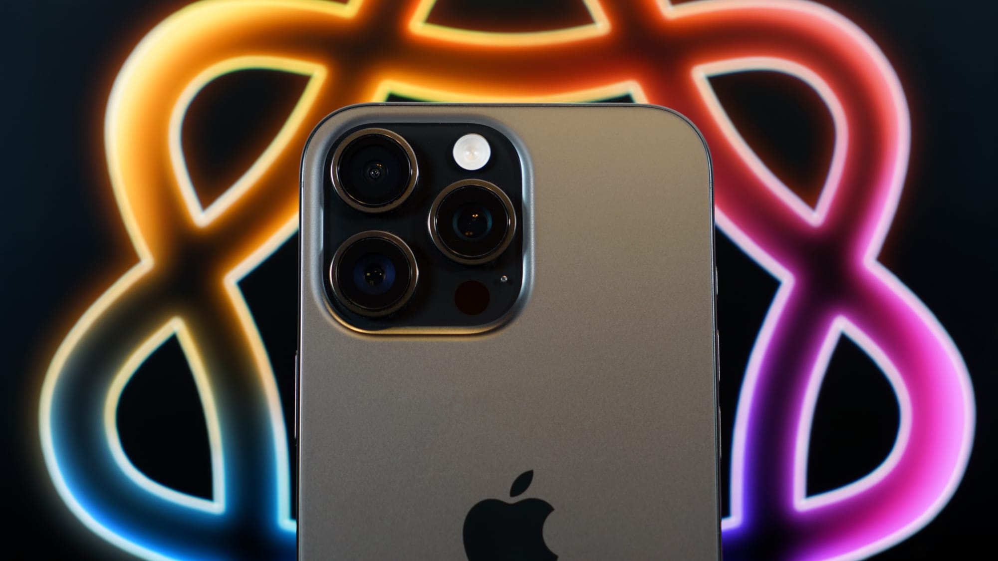 iPhone 16 Pro Max shot against an iPad Pro displaying the Apple Intelligence logo