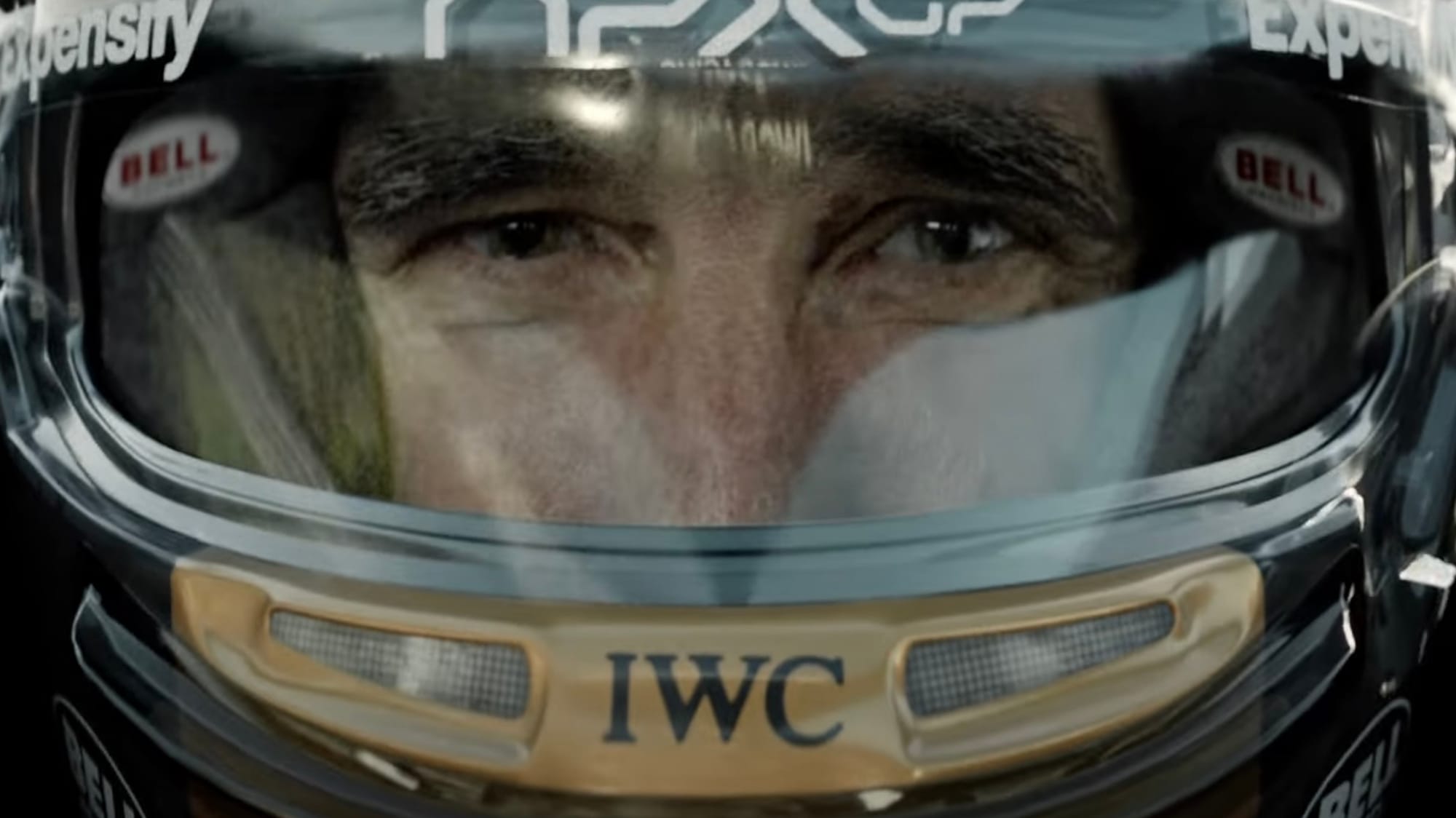 A zoomed in image of a man in a racing helmet