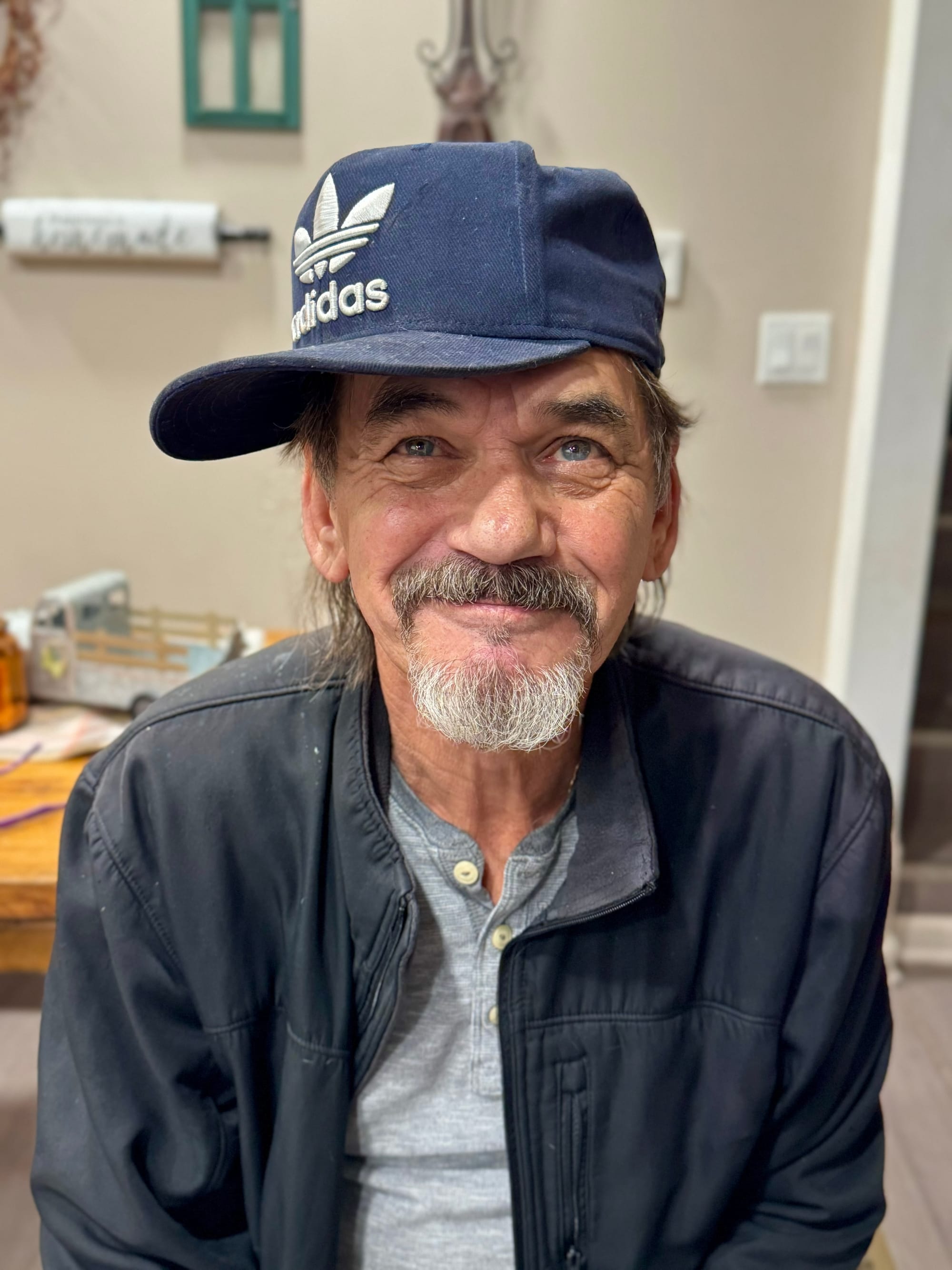 A photo of Wesley's Dad being silly with a sideways hat, smiling with a graying beard
