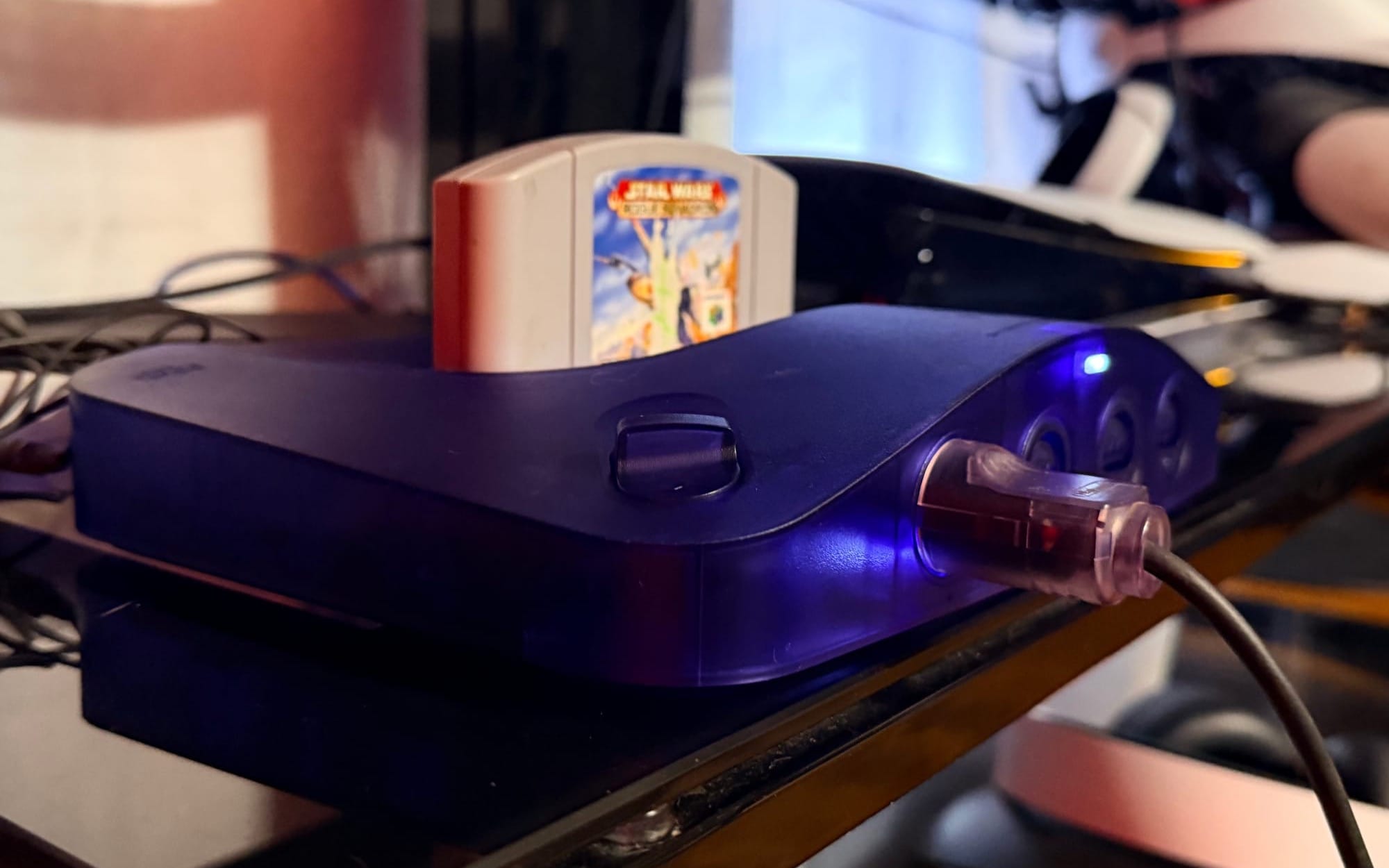 An Analogue 3D, the N64-like console with blue plastic and the cartridge for Star Wars: Rogue Squadron inserted.