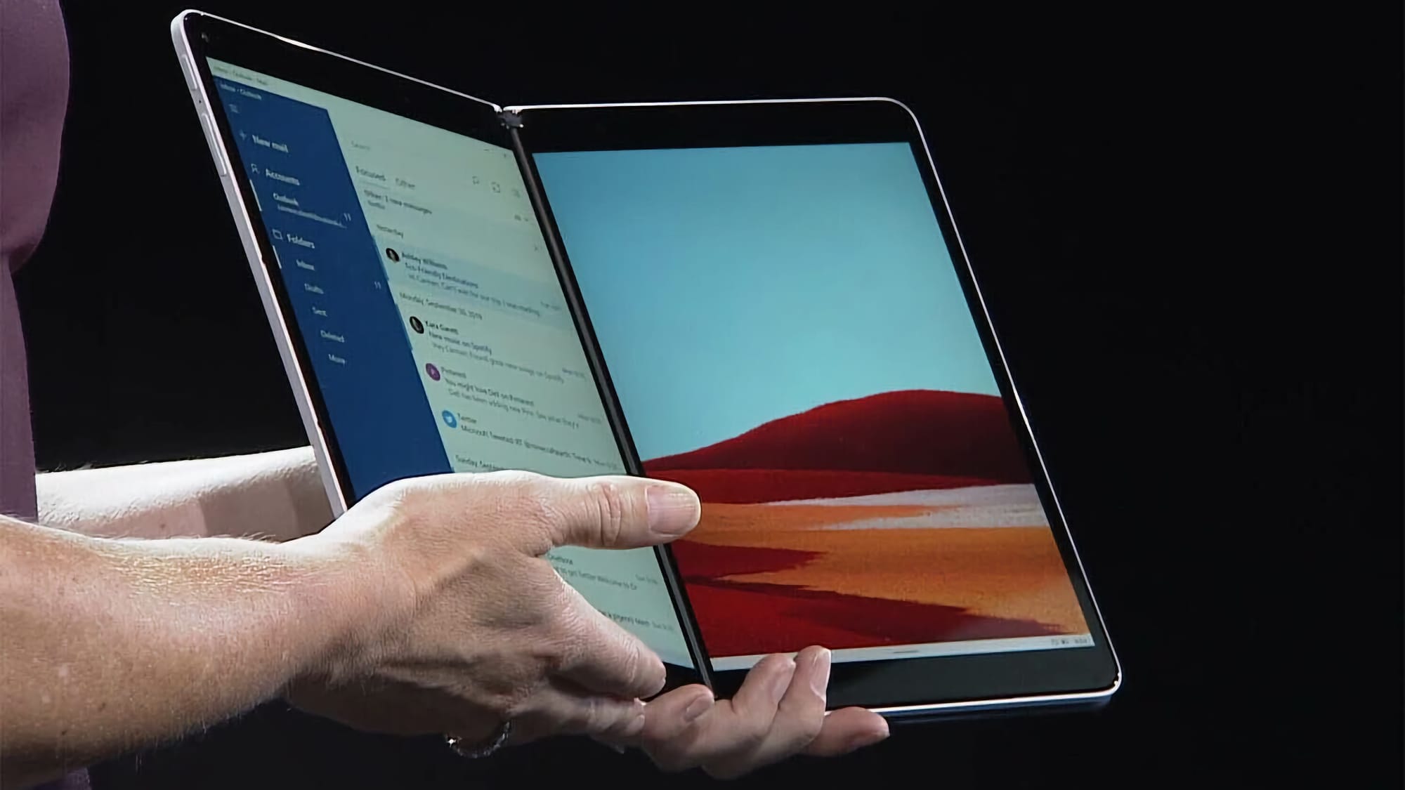 A person holds a folding tablet with two distinct displays