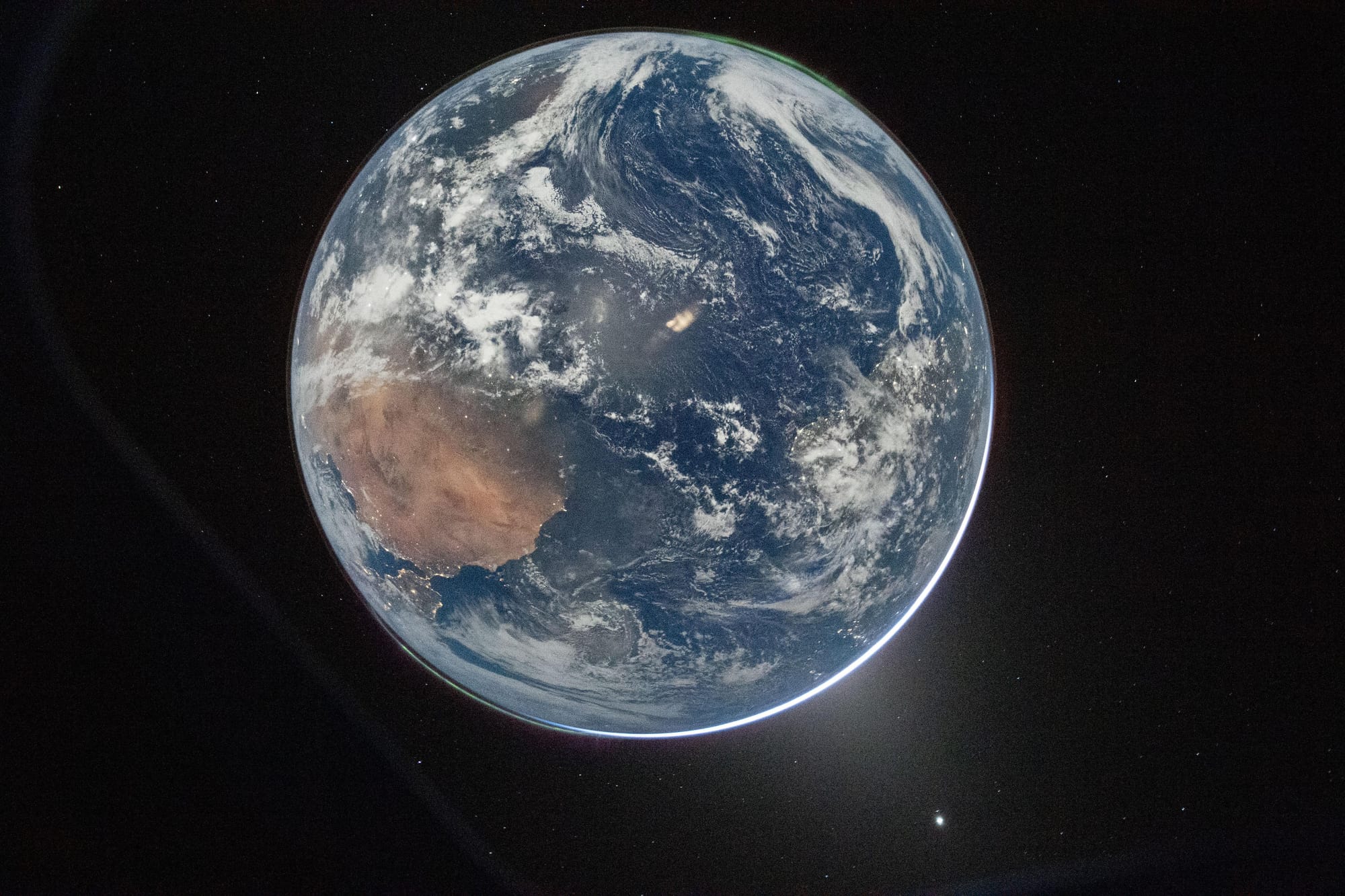 The earth viewed from a window on the Orion capsule, Europe is in the bottom left, Africa plainly visible, an aurora visible in the top right, and the sun is behind the Earth