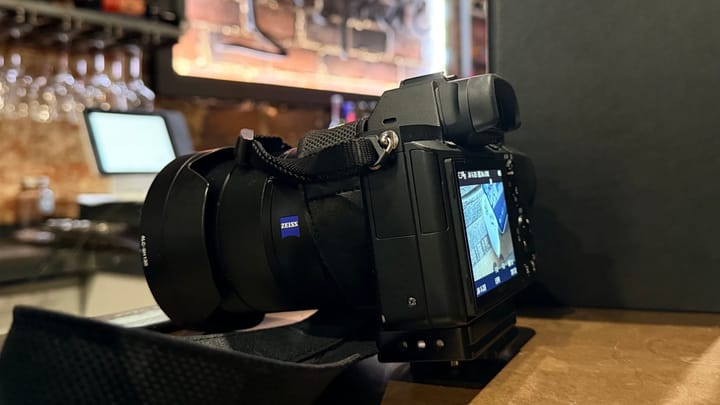A DSLR camera on a bar overlooking a wine selection and a sign for Inspire Wine Bar